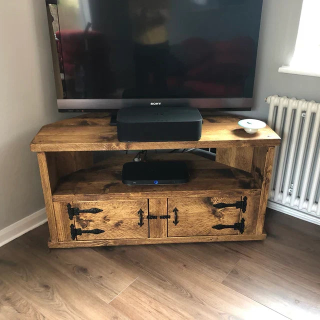 A rustic TV stand, handmade from solid wood in a classic country farmhouse style with cupboard space and a shelf.