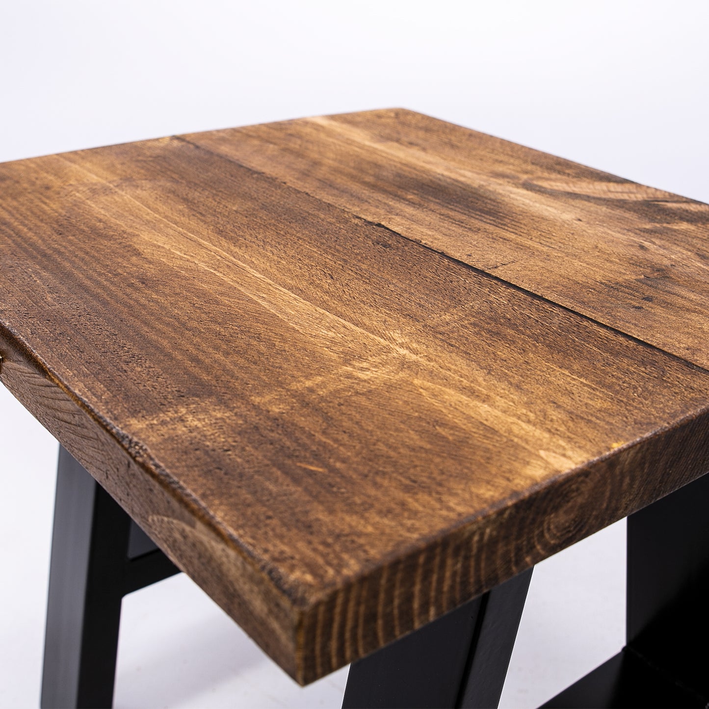 Handmade solid wooden stool with steel legs. Close up of corner