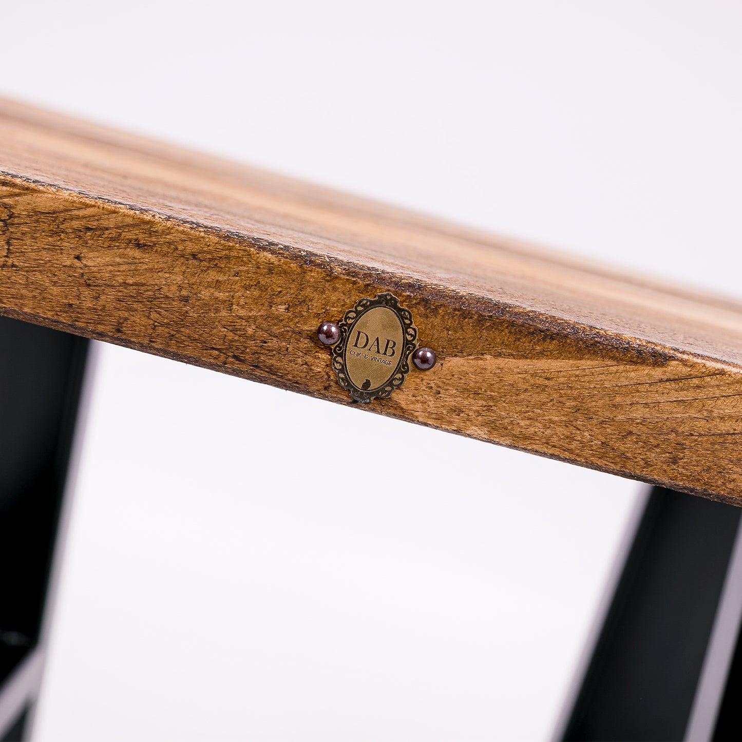 Handmade solid wooden stool with steel legs. Close up of badge