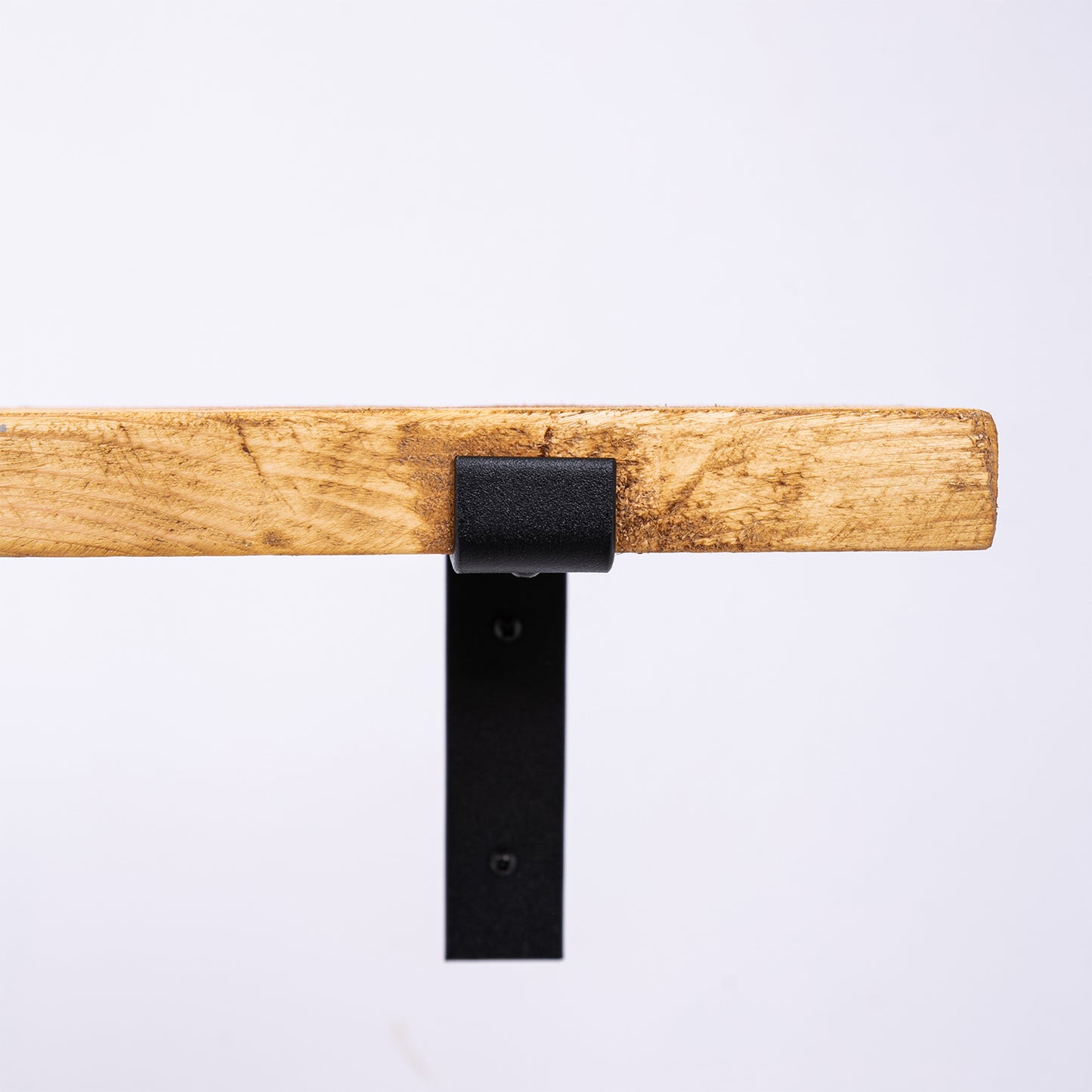 Handmade wooden shelf with black steel brackets. Close up of steel brackets