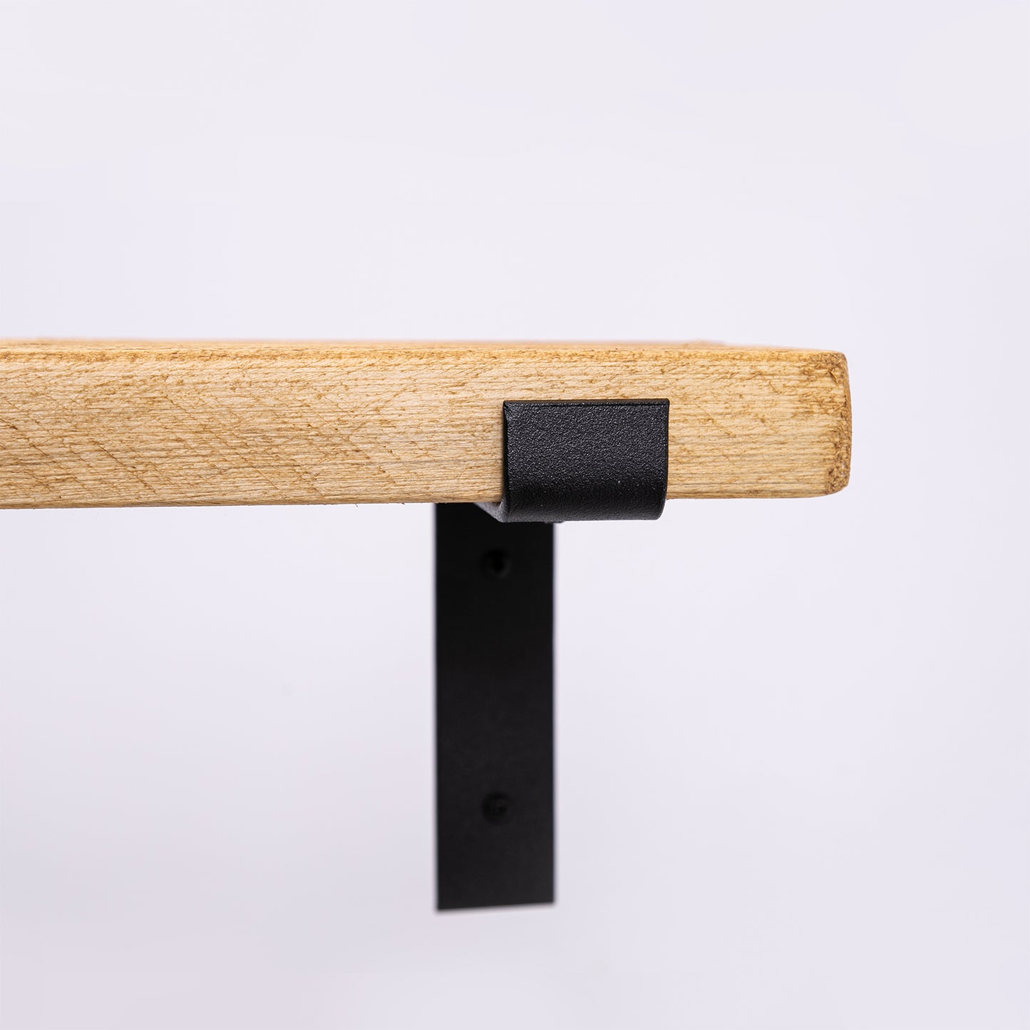 Handmade wooden shelf with black steel brackets. Close up of steelwork