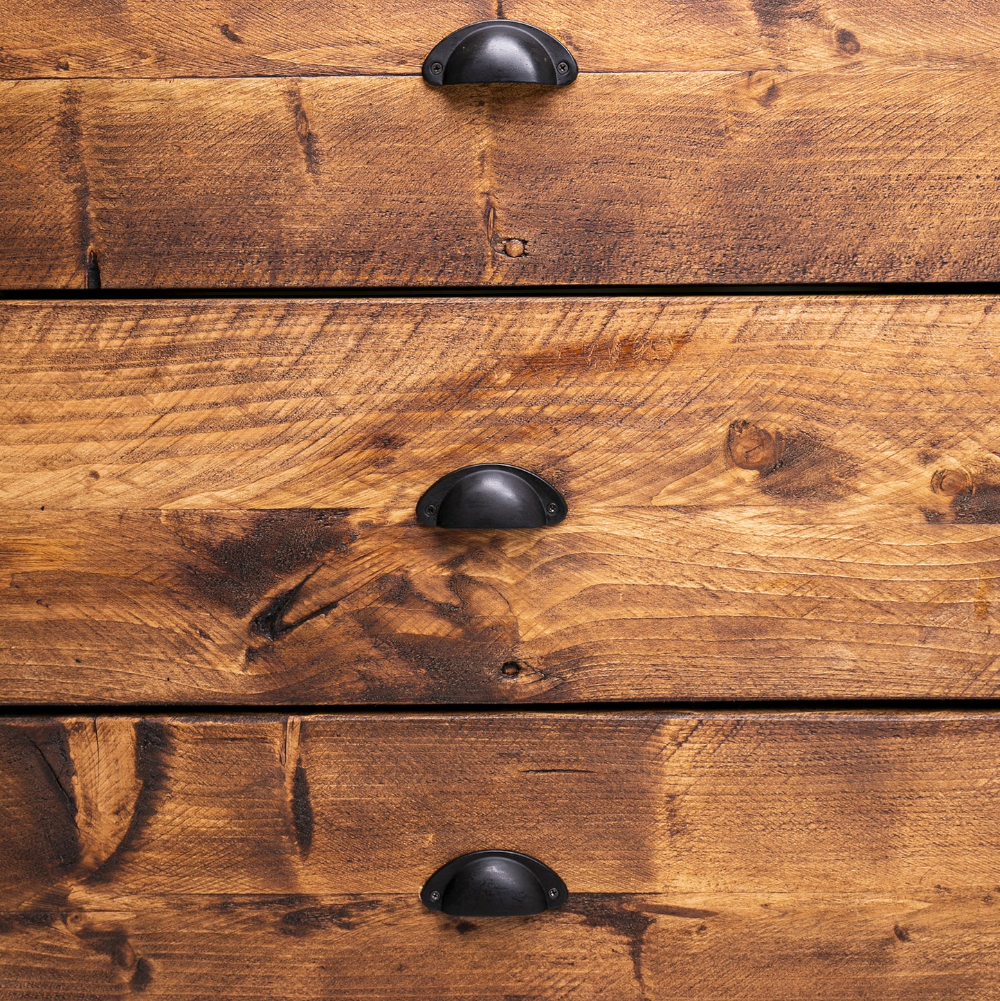 Wooden bedroom drawer set with black handles. Bespoke dresser close up of wood grain and drawer fronts