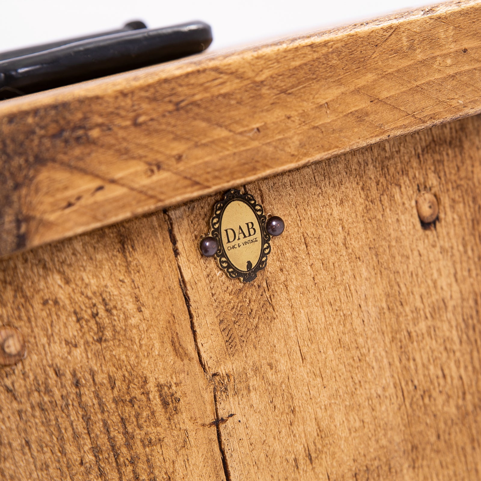 Close up of top of DAB heavy duty door stopper. Showing badge, wood grain and black steel handle
