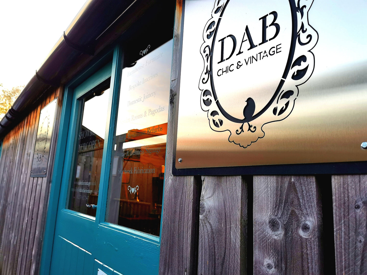 DAB Chic & Vintage wonderful showroom at Glebe Farm, Astbury, Cheshire. The shopfront has 2 beautiful stainless steel signs with a glass window double door and is the front face of our bespoke, wooden furniture & interiors business