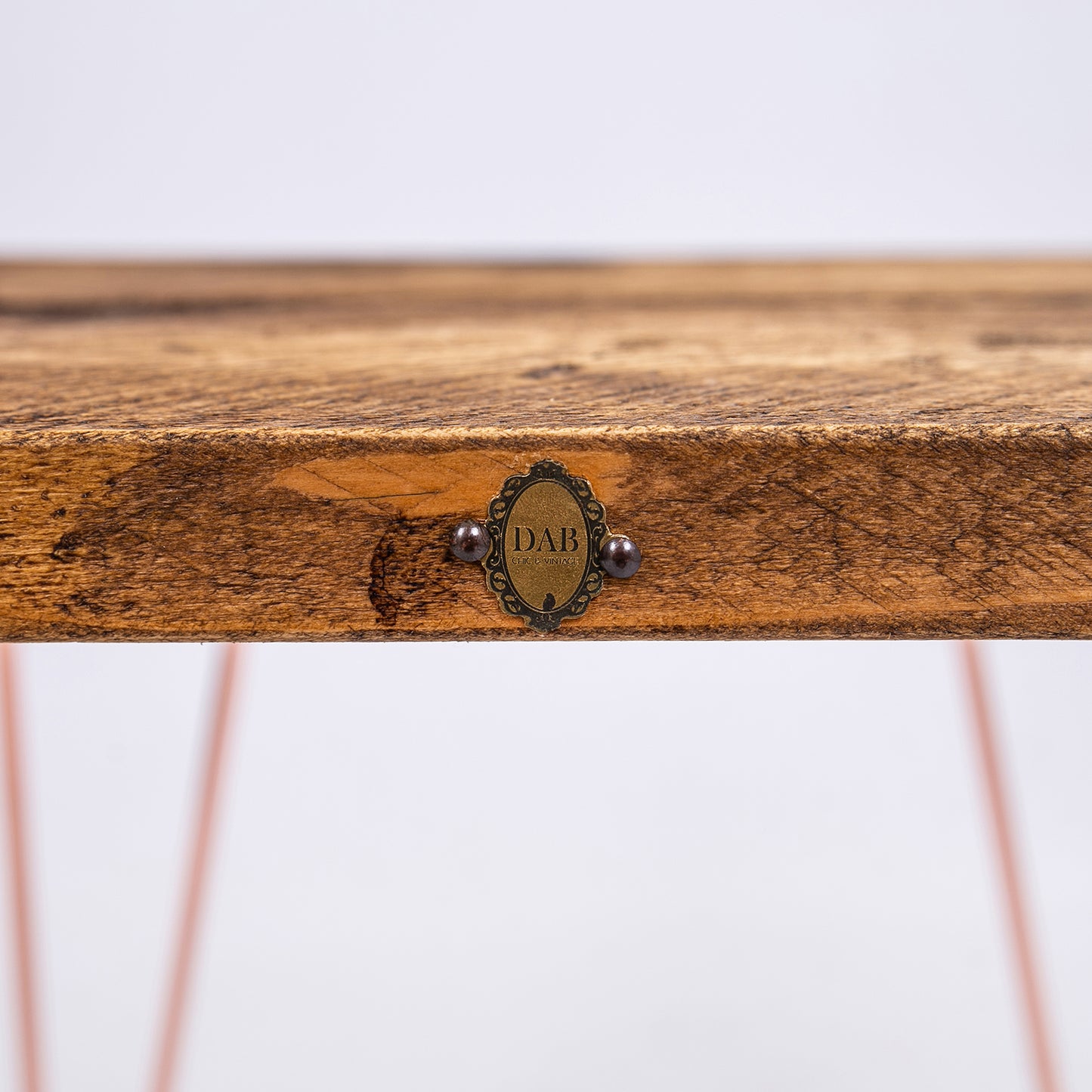 Steel Hairpin Bar Stool with rose gold hairpin legs. Close up of badge